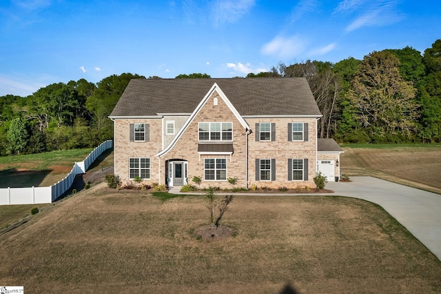 view of front of home with a front yard, an attached garage, fence, and concrete driveway