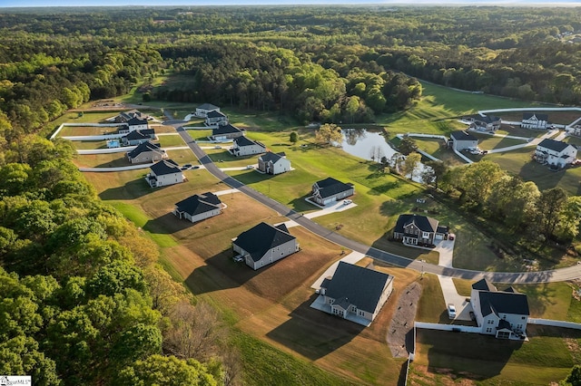 bird's eye view with a wooded view and a water view