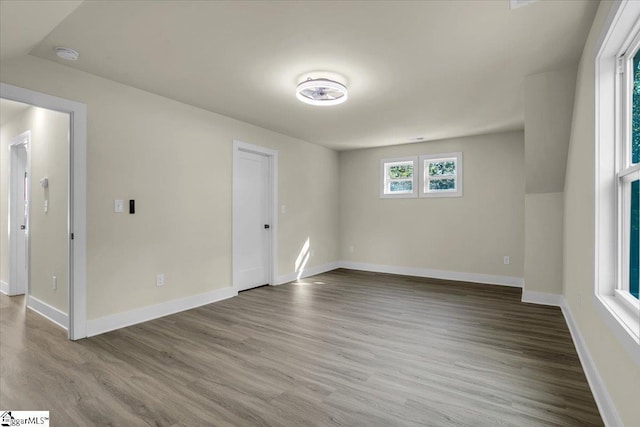 unfurnished room with baseboards and wood finished floors