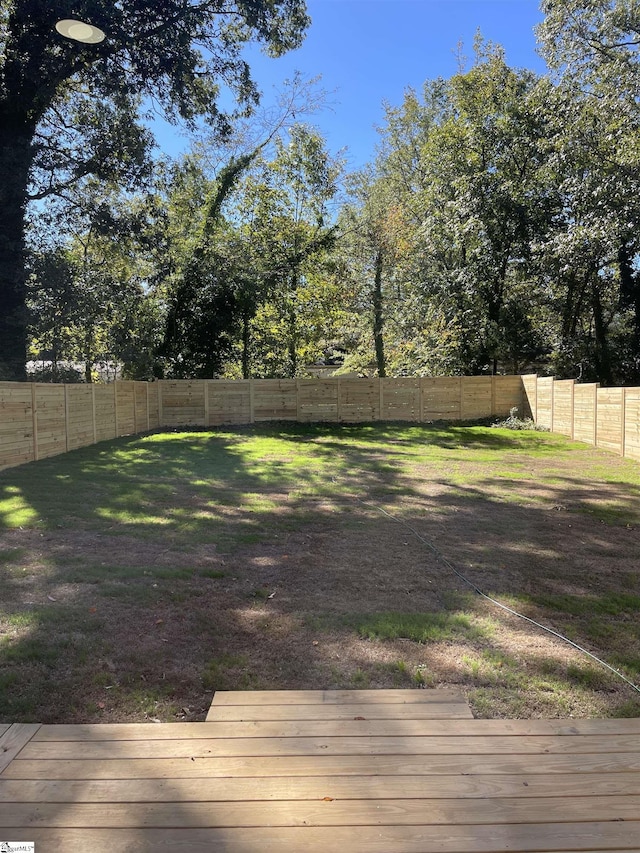 view of yard with a fenced backyard and a deck