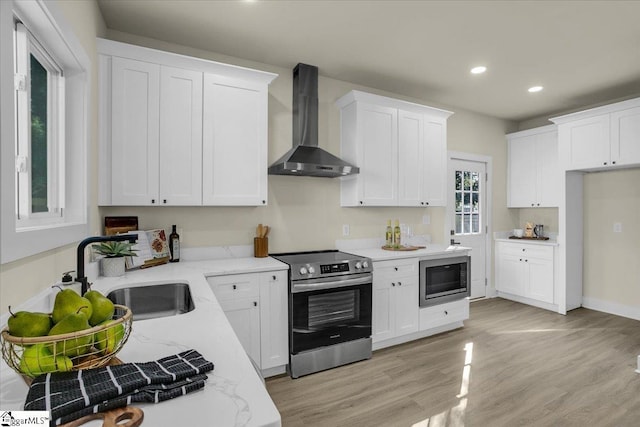 kitchen featuring wall chimney exhaust hood, stainless steel range with electric stovetop, light stone counters, a sink, and built in microwave