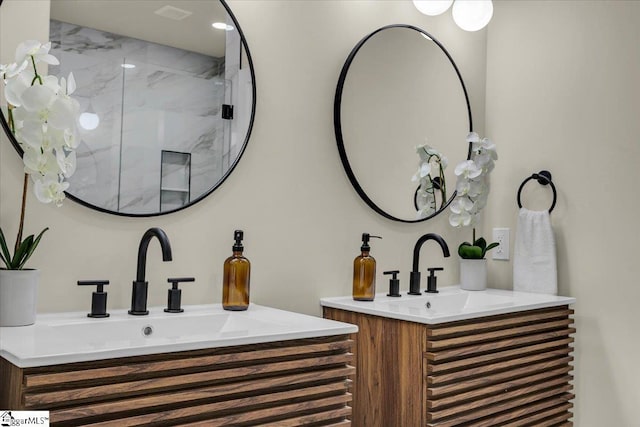 full bathroom with two vanities, a sink, and a marble finish shower