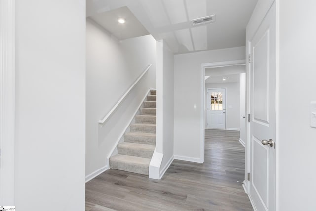 stairs with wood finished floors, baseboards, visible vents, and recessed lighting
