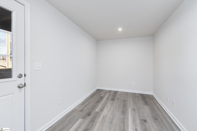 empty room with light wood-style floors, baseboards, and recessed lighting