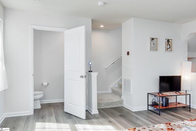 interior space featuring visible vents, baseboards, toilet, and wood finished floors