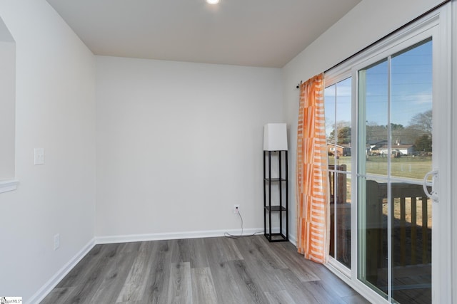 empty room featuring wood finished floors and baseboards