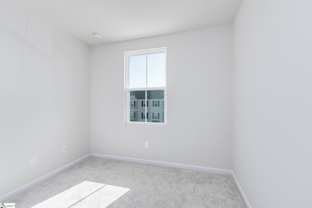 carpeted spare room featuring baseboards