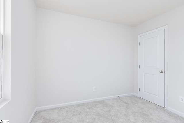 unfurnished room with carpet flooring and baseboards