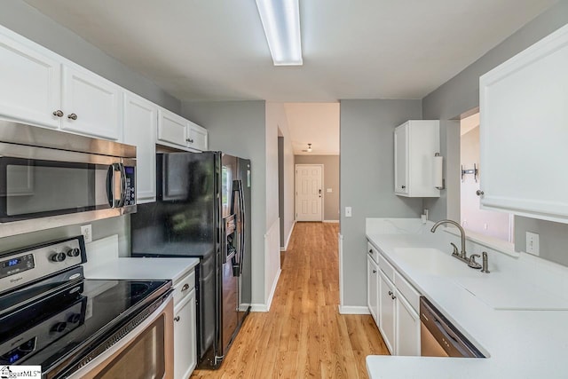 350 Hamilton Pkwy, Easley, SC 29642 - kitchen featuring light wood-type flooring, white cabinetry, light countertops, a sink, and stainless steel appliances