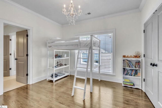 bedroom featuring crown molding, visible vents, a chandelier, and wood finished floors