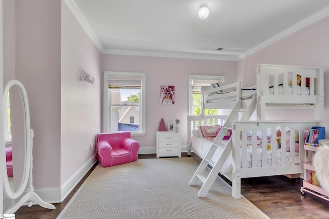 bedroom featuring crown molding, baseboards, and wood finished floors