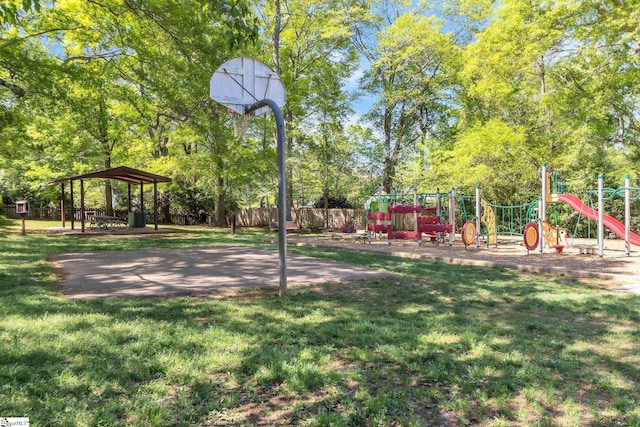 view of home's community featuring a yard, fence, community basketball court, and playground community