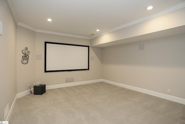 home theater room with ornamental molding, recessed lighting, and light carpet