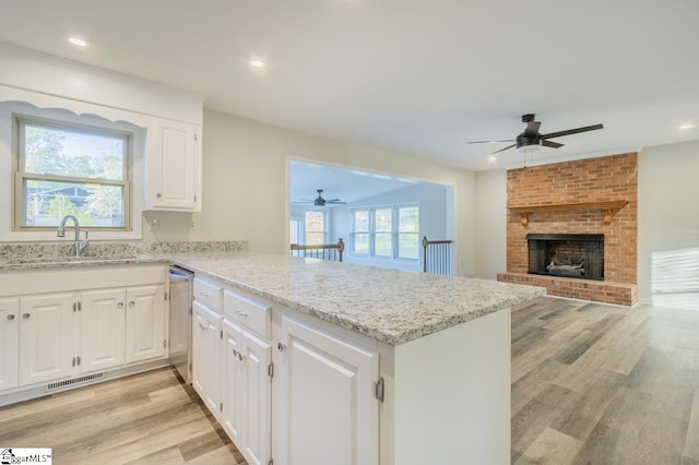 309 Frank St, Easley, SC 29642 - kitchen featuring a ceiling fan, light wood-style floors, a peninsula, white cabinetry, and stainless steel dishwasher