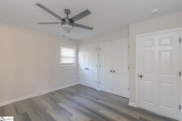309 Frank St, Easley, SC 29642 - unfurnished bedroom with visible vents, baseboards, a ceiling fan, multiple closets, and wood finished floors