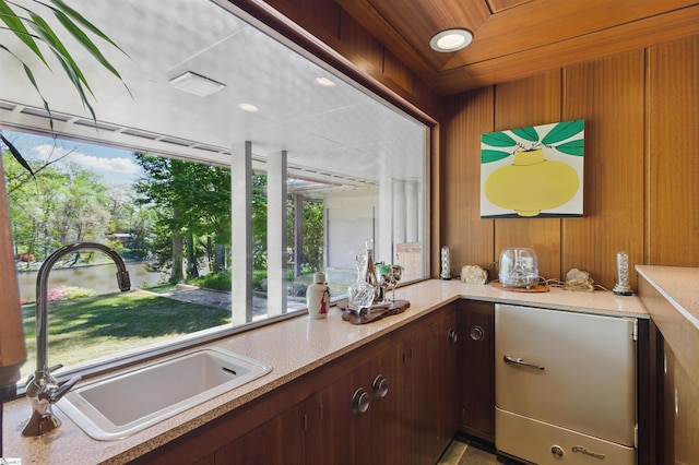 interior space with wood walls, light countertops, and a sink