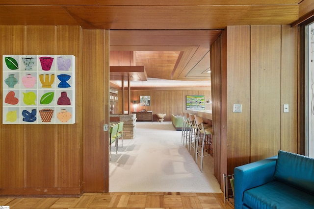 hallway with wooden ceiling and wooden walls