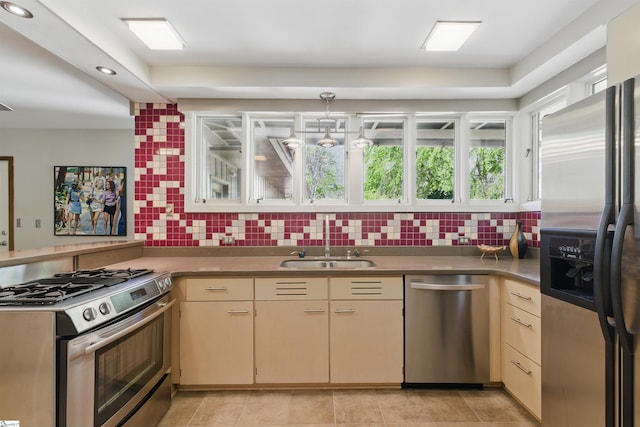 kitchen featuring a sink, appliances with stainless steel finishes, a peninsula, recessed lighting, and backsplash