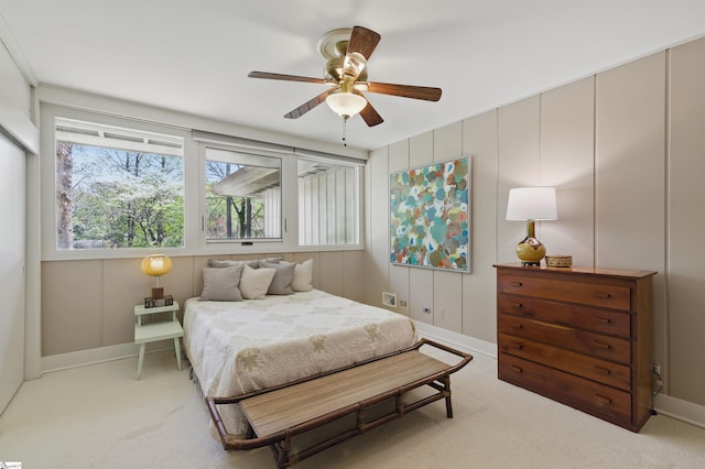 bedroom featuring light carpet, baseboards, and a ceiling fan