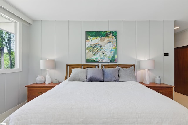 bedroom with a decorative wall and recessed lighting