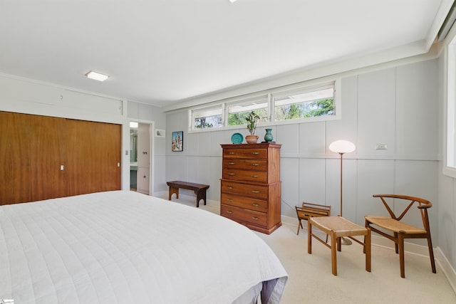 bedroom featuring a decorative wall and light colored carpet