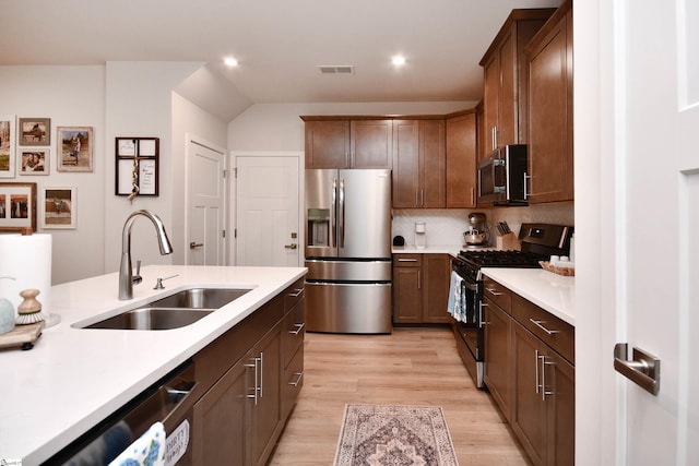 kitchen with light wood-style flooring, visible vents, appliances with stainless steel finishes, light countertops, and a sink