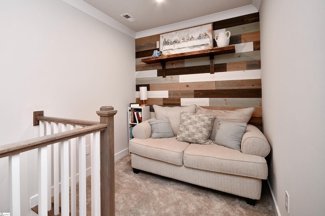 sitting room featuring wood walls, baseboards, carpet, and visible vents