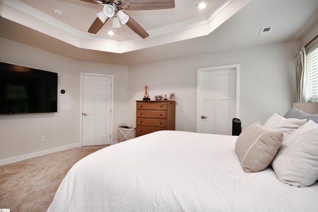 bedroom with baseboards, visible vents, a tray ceiling, ceiling fan, and carpet