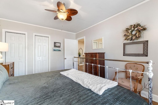 bedroom with a ceiling fan, two closets, baseboards, and ornamental molding