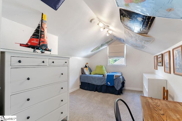 carpeted bedroom featuring baseboards, vaulted ceiling, and track lighting
