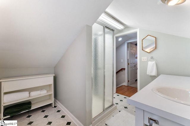 bathroom featuring vanity, a stall shower, and lofted ceiling