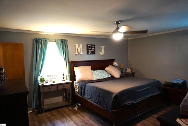 bedroom featuring dark wood-type flooring, ornamental molding, and a ceiling fan