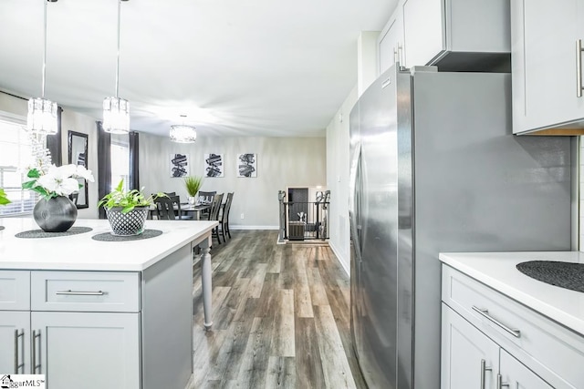 302 Pamela Ln, Laurens, SC 29360 - kitchen with hanging light fixtures, baseboards, light countertops, freestanding refrigerator, and wood finished floors