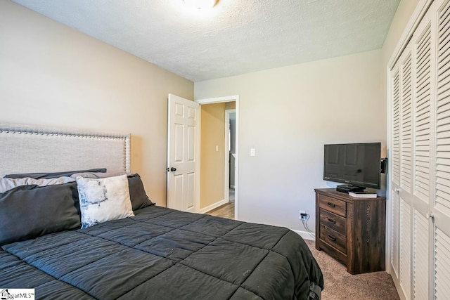 302 Pamela Ln, Laurens, SC 29360 - carpeted bedroom featuring a closet, baseboards, and a textured ceiling