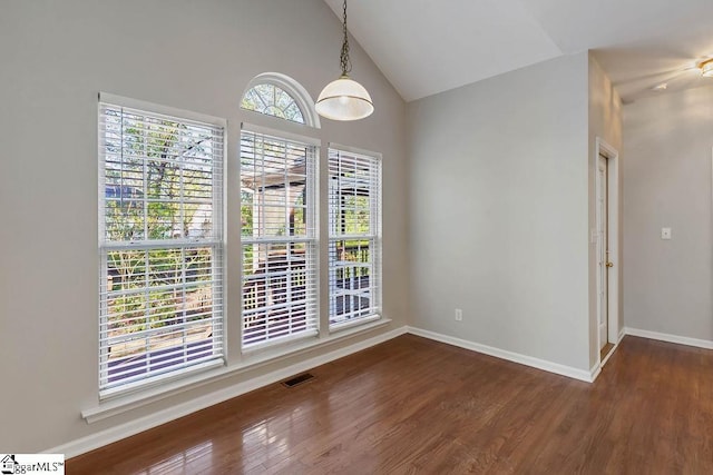 unfurnished dining area with visible vents, baseboards, vaulted ceiling, and wood finished floors