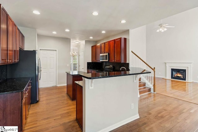 kitchen featuring recessed lighting, light wood-type flooring, a breakfast bar area, and stainless steel appliances