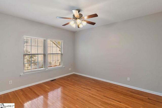 empty room with light wood-style floors, a healthy amount of sunlight, and baseboards