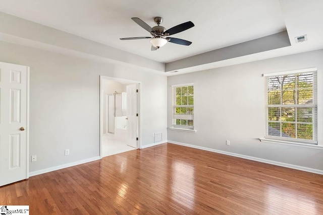 unfurnished bedroom featuring baseboards, wood-type flooring, a ceiling fan, and visible vents