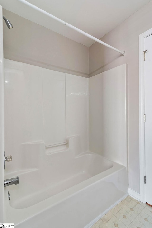 bathroom featuring baseboards and  shower combination