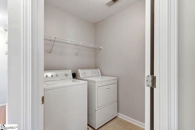 laundry area with visible vents, washer and clothes dryer, laundry area, and baseboards