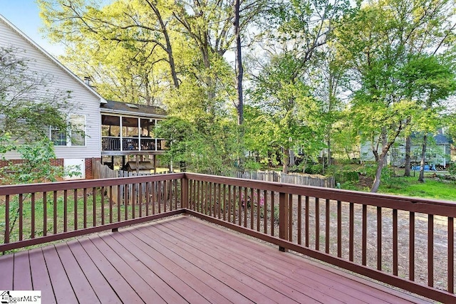 wooden deck with fence and a sunroom