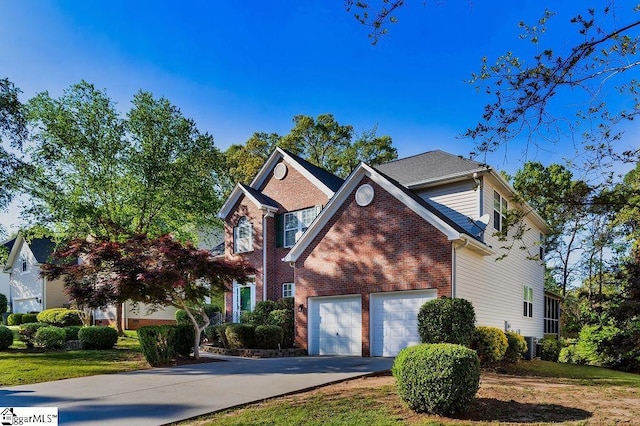 traditional-style home featuring brick siding, an attached garage, and driveway