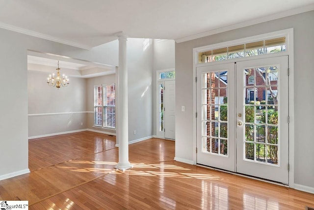 foyer entrance featuring french doors, baseboards, ornamental molding, ornate columns, and wood-type flooring