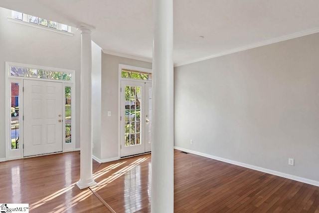 entrance foyer with baseboards, wood-type flooring, ornate columns, and crown molding