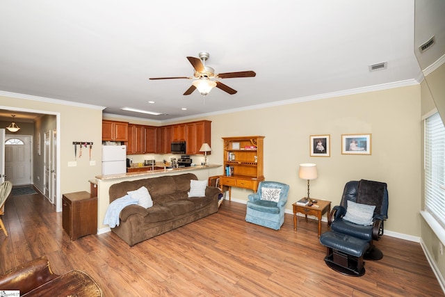 living room featuring visible vents, baseboards, a ceiling fan, and wood finished floors