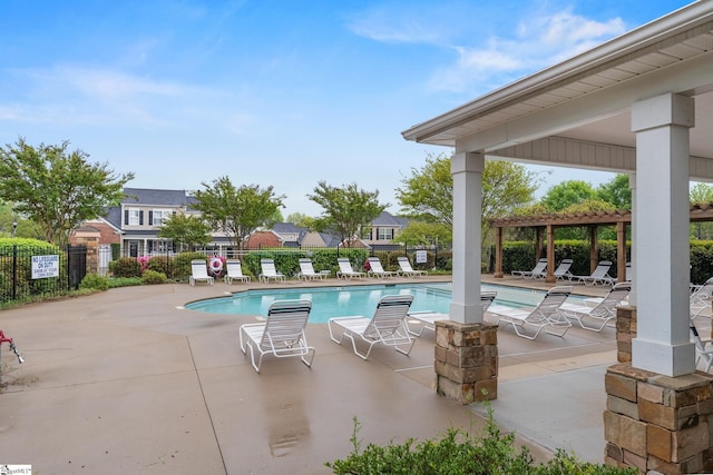 community pool with a patio and fence