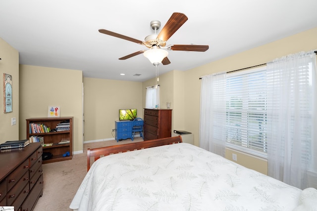 bedroom with baseboards, a ceiling fan, and light carpet