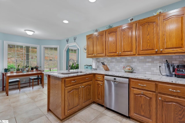 kitchen featuring brown cabinetry, a baseboard radiator, stainless steel dishwasher, and a sink