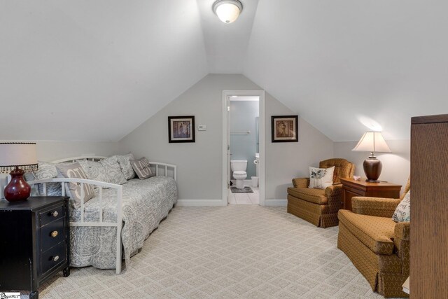 carpeted bedroom featuring baseboards, vaulted ceiling, and connected bathroom