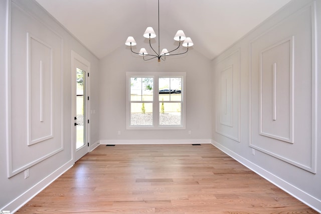 unfurnished dining area featuring a notable chandelier, baseboards, visible vents, lofted ceiling, and light wood finished floors